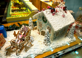 Gingerbread house and sleigh with deer, showcase confectionery shop, night in the new year.