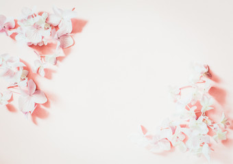 Styled feminine flat lay on pale pastel pink background, top view. Minimal woman's desktop with blank page mock up,  spring lilac  flower, Creative concept 