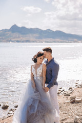 Fototapeta na wymiar Beautiful wedding couple on the background of the rocks and sea. Close-up portrait