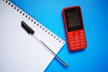 Red phone with buttons on blue background.
