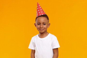 Happy childhood, joy, celebration and holidays concept. Portrait of joyful birthday boy wearing...