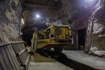 Fototapeta na wymiar Underground gold ore mine shaft tunnel gallery passage with load, haul, dump machine LHD
