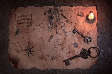 flat lay pirate table, old map with keys and real candle flame, treasures and adventures