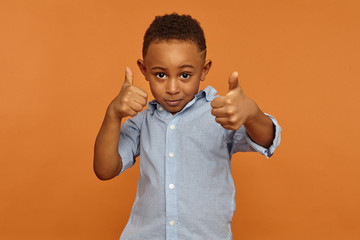 Human reaction, feelings, emotions and body language. Handsome charming African American little boy...