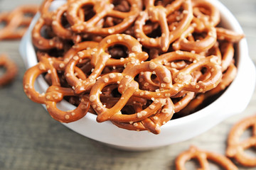Hard Pretzels or Salted pretzels snack for party in white bowl on wooden floor.