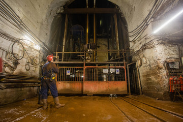 Underground gold ore mine shaft tunnel lifting cage and miner
