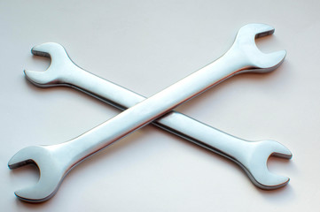 Two wrenches lie crosswise on a white background