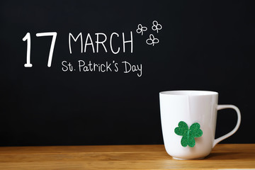 Saint Patricks Day message with a white mug on black background