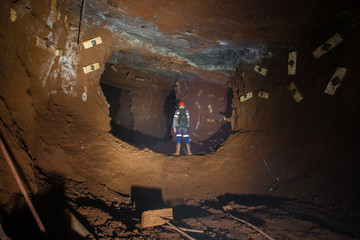 Underground gold ore mine shaft tunnel gallery passage with miner