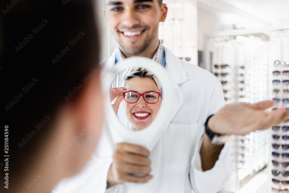 Poster young optometrist helps customer to choose right eyeglasses