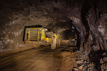 Fototapeta na wymiar Underground gold ore mine shaft tunnel gallery passage with machine