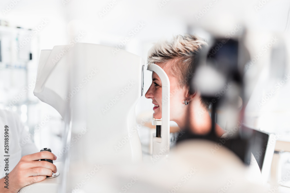 Poster male optometrist checking patient's vision at eye clinic. medical examination.