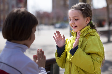 boy with girl clap outdoors in autumn
