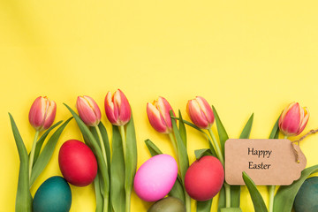 Easter eggs painted and tulips with yellow background and text happy easter