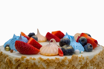 Isolated birhtday cake decorated with marshmallow, strawberries and blueberries