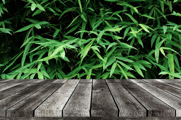 empty wooden board, table or modern wooden terrace with image of dark green plant tropical bamboo...