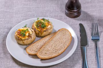 Staffed mashrooms with slices of bread on the plate.