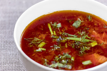 Red borsch decorated with s dill in a bowl