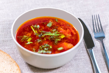 Red borsch decorated with s dill in a bowl
