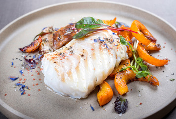 Gebratenes dänisches Skrei Kabeljau Fisch Filet mit Kürbis, Kräuterseitling und Salat als...