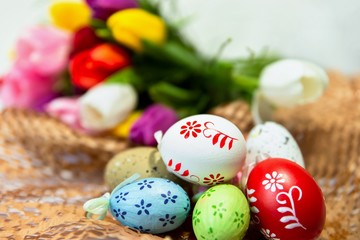 Easter arrangement with decorative eggs and tulips.