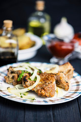 Pork meat barbecue with marinated onions on a wooden background