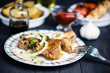 Pork meat barbecue with marinated onions on a wooden background