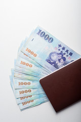 Passport and 1000 New Taiwan Dollar bill on white background