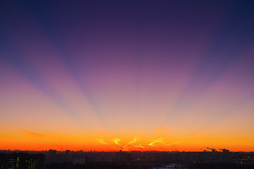 Orange clouds with aircraft trails sky background and city light midnight evening time