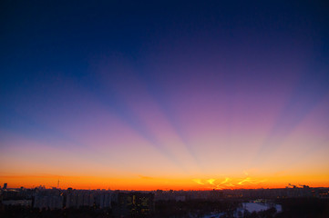 Orange clouds with aircraft trails sky background and city light midnight evening time