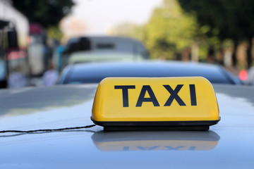 Taxi light sign or cab sign in yellow color with black text on the car roof.