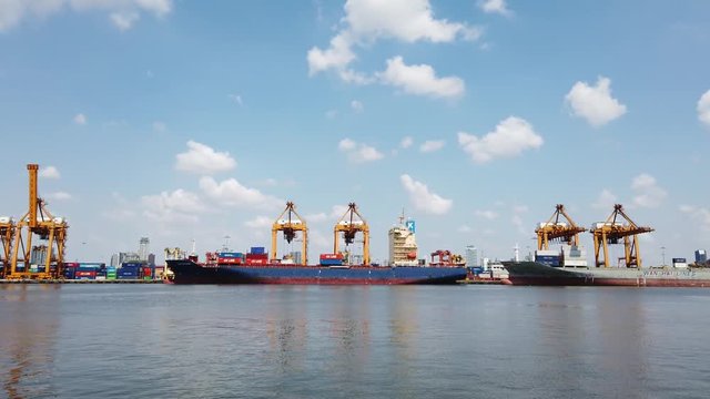 Container ship in export and import business and logistics in Khlong Toei port Thailand. Shipping cargo to harbor by crane. Water transport International.