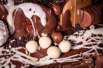 Chocolate, chocolate cookies and candies like a decoration on homemade cake