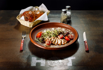 Chicken breast salad laid out on a clay plate.