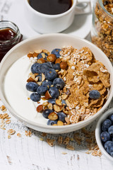 bowl of healthy wholegrain flakes, yogurt and fresh blueberries for breakfast, vertical closeup