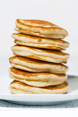 stack of delicious pancakes on a plate, vertical closeup