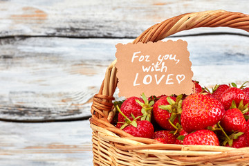Strawberries in basket and romantic note. Healthy ripe strawberries and Valentines Day vintage card...