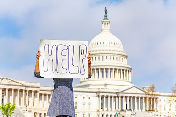 Protester holding sign in hands asking for help