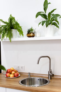 Modern white kitchen in scandinavian style. kitchen sink white with flowers and fruit pepper and fern
