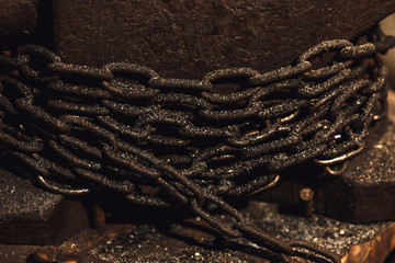 close up chain coiled around anvil base.
