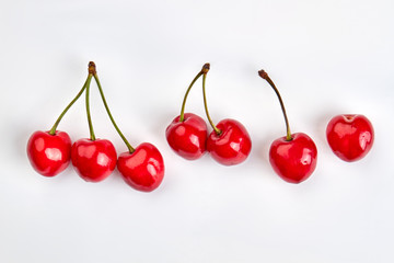 Obraz na płótnie Canvas Row of ripe cherries on light background. Red juicy berries, studio shot.