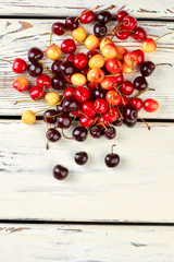 Heap of ripe cherries, top view. Mis of juicy berries on wooden background and copy space.