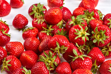 Ripe fresh strawberries background. Red juicy berries with green leaves close up. Rich with vitamins.