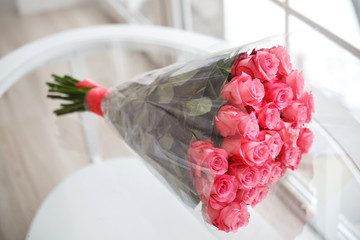 A bouquet of pink roses on a glass table.