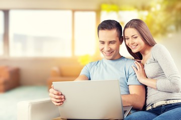 Young business couple using laptop at home, online shopping with credit card
