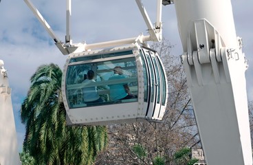 Ferris wheel. People look at the panorama of the Spanish city of Malaga from the Ferris Cabin.