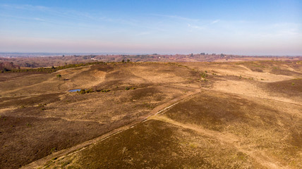 Fototapeta na wymiar Aerial view of the New Forest National Park with heathland and forest trails under a majestic blue sky