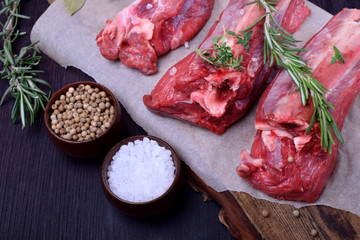 Raw beef ribs, rosemary, thyme and spices on a wooden board