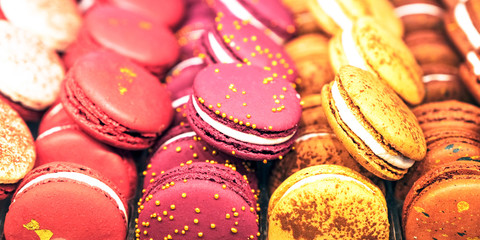 Almond cookies in a gift box and marshmallows. Multicolored meringues close-up top view. Sweet pasta and flowers. Selective focus. Macaroons are a dessert loved by millions.