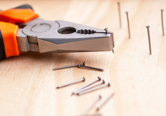 Hammer, nails and pliers lie on a wooden background. Construction Tools Selective Focus